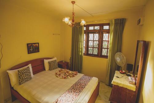 a bedroom with a bed and a window at Jaya Tomodachi in Kandy