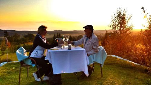 two people sitting at a table with wine glasses at Hotel Pod Kokšínem in Spálené Poříčí