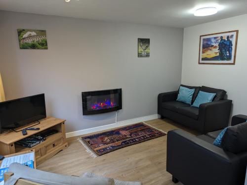 a living room with a couch and a fireplace at The Little Houses in Roybridge
