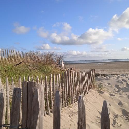 a wooden fence in the sand on a beach at Aux 10 Ponts Maison spacieuse et conviviale au bord de la Somme la mer à 30 min 6 personnes in Pont-Rémy
