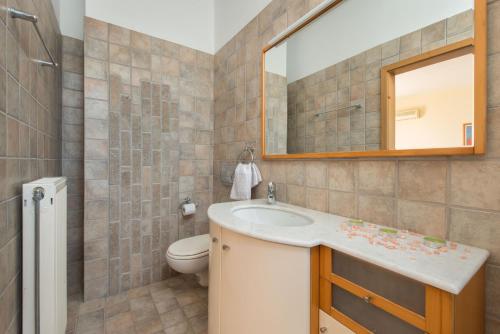 ein Badezimmer mit einem Waschbecken, einem WC und einem Spiegel in der Unterkunft Villa Amelia in Gennadi
