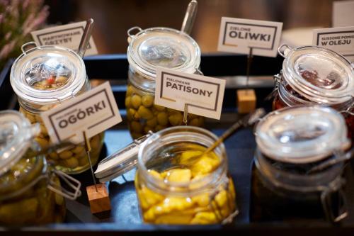 a bunch of jars of pickles on a table at Q Hotel Plus Wrocław Bielany in Wrocław
