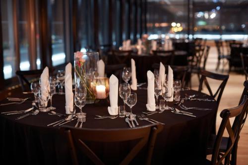 a table with wine glasses and candles on it at Q Hotel Plus Wrocław Bielany in Wrocław