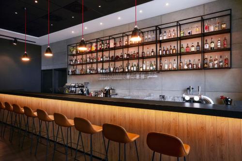 a bar with a row of bar stools at Q Hotel Plus Wrocław Bielany in Wrocław