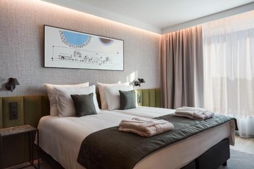 a bedroom with a large bed with pillows on it at Q Hotel Plus Wrocław Bielany in Wrocław