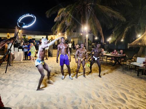 a group of men playing volleyball on the beach at night at Tamala Beach Resort in Kotu
