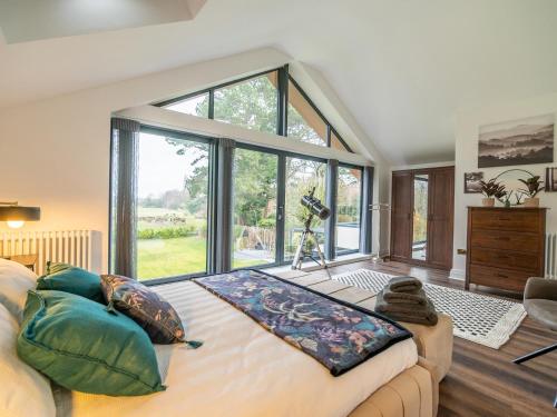 a bedroom with a bed with a large window at The Golf House in Bidston