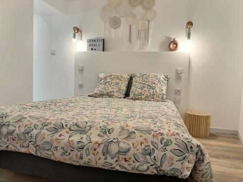 une chambre avec un lit avec un couvre-lit fleuri dans l'établissement Le Petit Evali - WIFI - Centre, à Albi
