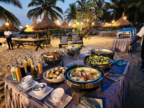 a table with food on the beach at night at Tamala Beach Resort in Kotu