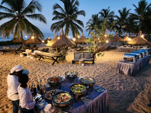 a table on the beach with food on it at Tamala Beach Resort in Kotu