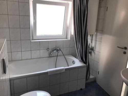 a bathroom with a bath tub and a window at Pension Altstadt Garni in Bad Windsheim