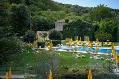 a resort with a pool with chairs and umbrellas at Terme Preistoriche Resort & Spa in Montegrotto Terme