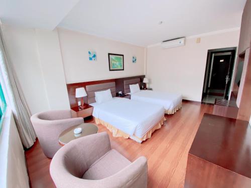 a hotel room with two beds and a couch at Muong Thanh Thanh Nien Vinh in Vinh