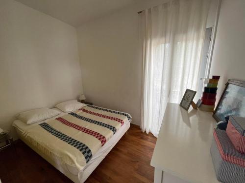 a bedroom with a bed and a window with white curtains at 4DEMO2 Appartement vue mer in Collioure