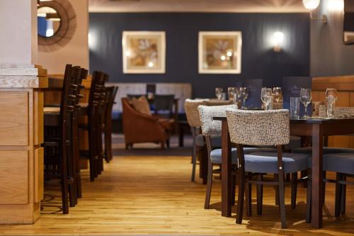a dining room with tables and chairs in a restaurant at Burntwood Court Hotel in Barnsley