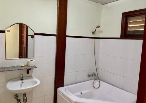 een badkamer met een wastafel, een toilet en een spiegel bij Khách sạn Sao Mai in Ben Tre