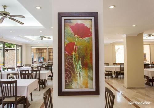 a painting of two red flowers on a wall in a restaurant at MURAT 2 Hotel in Kemer