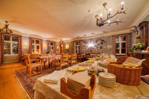 una sala da pranzo con tavoli, sedie e lampadario a braccio di Hotel Zur Eule a Oldenburg in Holstein