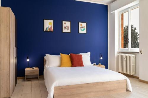 a blue bedroom with a bed with colorful pillows at Accomodo MIT12 Trivano Linate in Milan