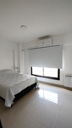 Habitación blanca con cama y ventana en Azucena Apart II en Salta