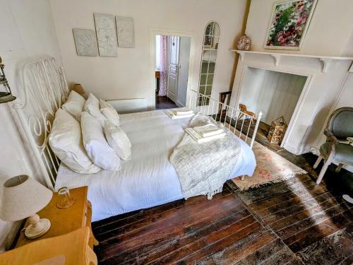 sypialnia z białym łóżkiem i kominkiem w obiekcie Sous le Chateau w mieście Jumilhac-le-Grand