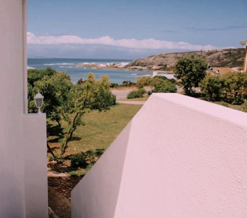 a white wall with a view of the ocean at Struispaleis in Struisbaai