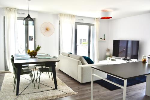 sala de estar con mesa y sofá en 5-Min Paris, Lovely Eco Brand-New Sun-Bathed Apt !, en Aubervilliers