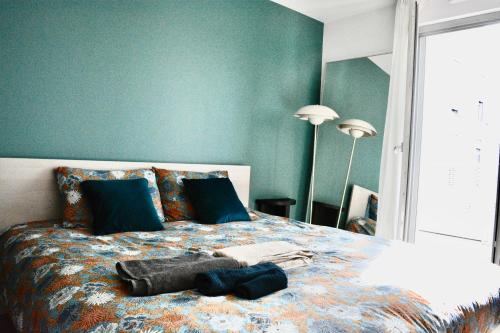 1 dormitorio con 1 cama grande y paredes azules en 5-Min Paris, Lovely Eco Brand-New Sun-Bathed Apt !, en Aubervilliers