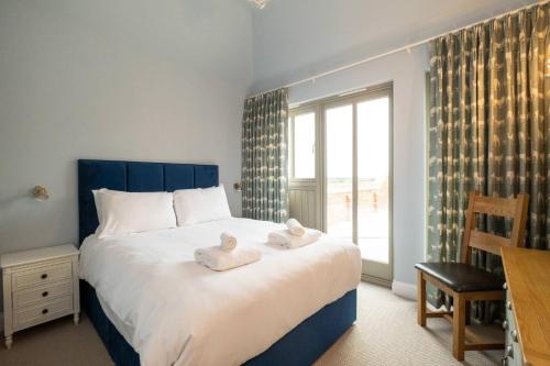 a bedroom with a large bed with towels on it at Alde Bay Farm - Coral Cottage in Aldeburgh