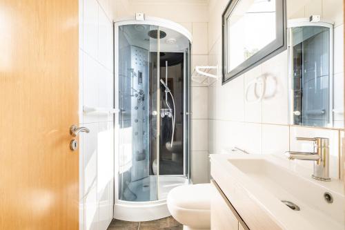 a bathroom with a shower and a toilet and a sink at Ocean Panorama Apartments by Madeira Sun Travel in Calheta