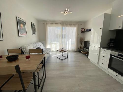 une cuisine et un salon avec une table et un canapé dans l'établissement Sol-y-Days Baroncelli, Appartement rénové avec vue latérale sur mer et proche du centre ville, au Grau-du-Roi