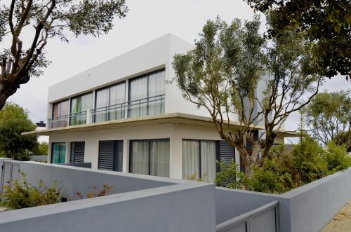 a house with a white fence and trees at VILAS ESPÍRITO SANTO by brugrani in Porto Santo