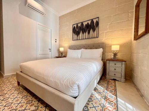 a bedroom with a large bed and two night stands at Typical Maltese Maisonette in St.Julians in St. Julianʼs