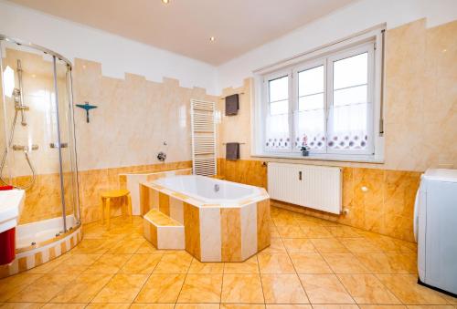 y baño grande con bañera y ducha. en Ferienwohnung ALEX, en Burgau