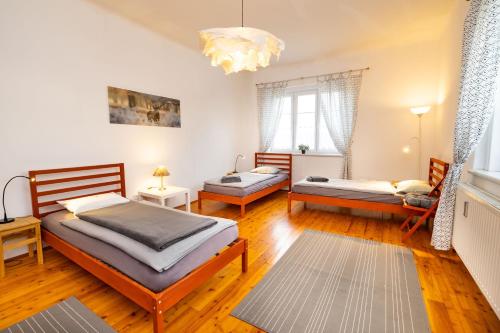 a bedroom with two beds and a chandelier at Ferienwohnung ALEX in Burgau