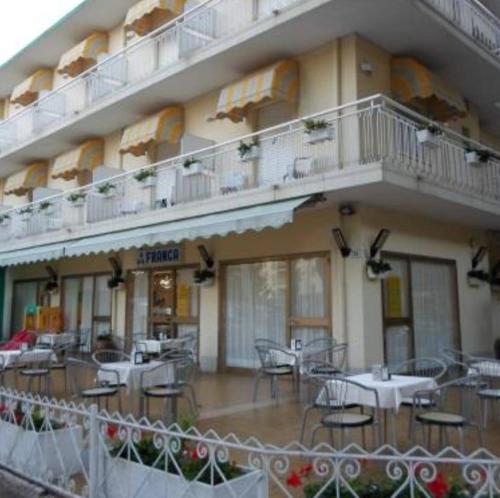 un hotel con tavoli e sedie di fronte a un edificio di Hotel Franca a Misano Adriatico