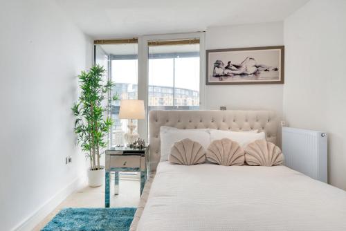 - une chambre avec un lit et une table avec une lampe dans l'établissement Large 2Bed 2Bath Apartment Beautiful River Views London Greenwich Cutty Sark, à Londres