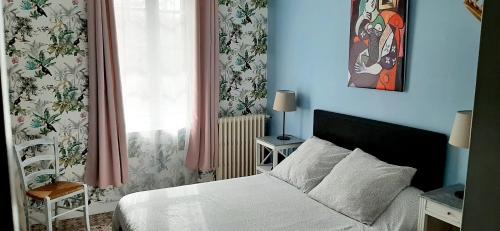 a bedroom with a white bed and a window at le Mas d'Hubert in LʼIsle-sur-la-Sorgue