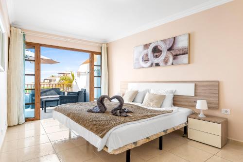a bedroom with a bed and a balcony at Luxury Apartaments in Costa Adeje, Los Geranois in Adeje