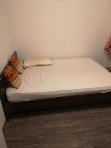 ein Bett mit weißer Bettwäsche und Kissen darauf in der Unterkunft Belle maison de vacances in Romilly-sur-Seine