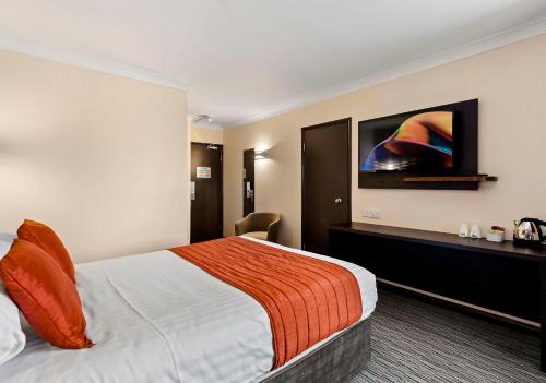 a hotel room with a bed and a flat screen tv at Dragonfly Hotel King's Lynn in Kings Lynn