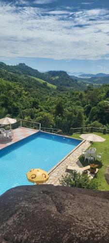 een groot zwembad met uitzicht op de bergen bij Pousada La Dolce Vita Paraty in Paraty