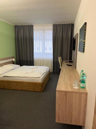 a bedroom with a bed and a desk and a television at Amantis Vital Sport Hotel in Desná