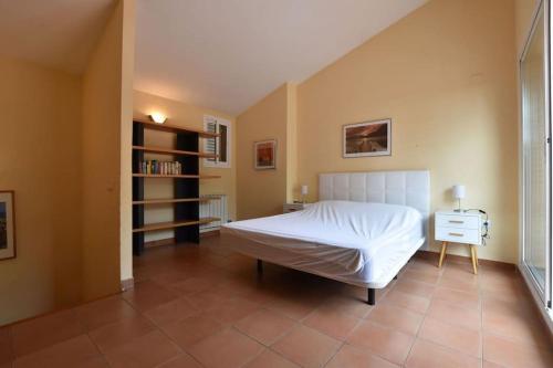 una camera con un letto bianco e una libreria di Preciosa zona natural La Mora a Tarragona
