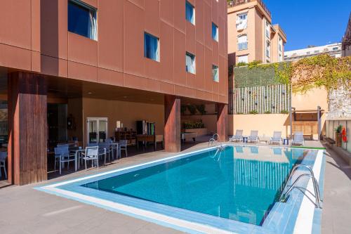 una piscina frente a un edificio en Hotel Macià Real De La Alhambra, en Granada