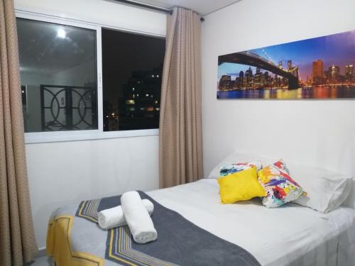 a bedroom with a window and a bed with towels at Apartamento no centro de São Paulo in Sao Paulo