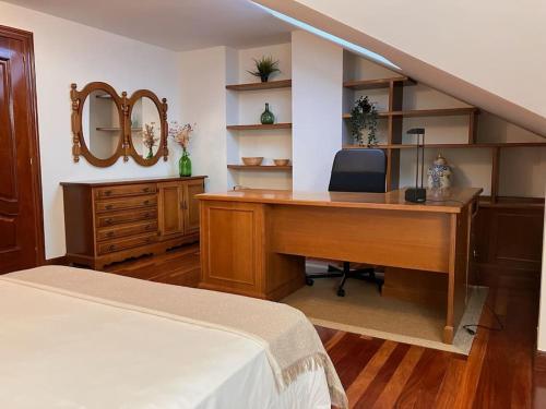 1 dormitorio con escritorio, cama y espejo en Apto Dúplex, 122 m2, Wifi 1GB, centro Mundaka, en Mundaka