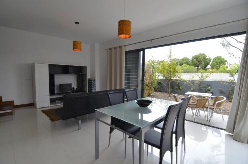 a dining room and living room with a table and chairs at Vilas Espírito Santo in Porto Santo