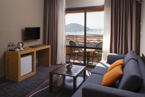 a living room with a blue couch and a balcony at Suhan Seaport Hotel in Kusadası