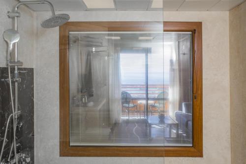 a glass window in a room with a table at Suhan Seaport 360 Hotel in Kuşadası